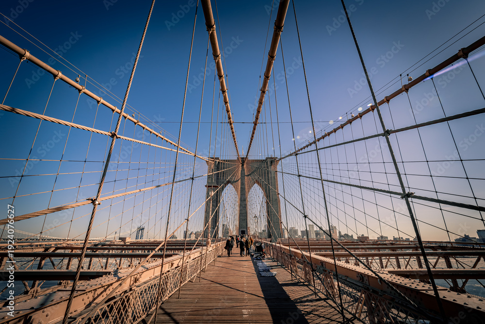 Fototapeta premium Breathtaking view of the famous Brooklyn Bridge crossing the East River in New York City, NY, USA, on a cold winter day looking towards Brooklyn