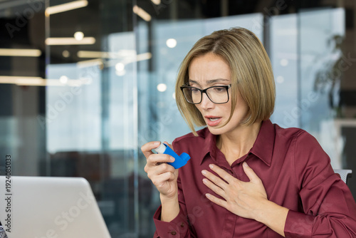 Photos Woman experiencing an asthma attack and difficulty breathing in a modern office