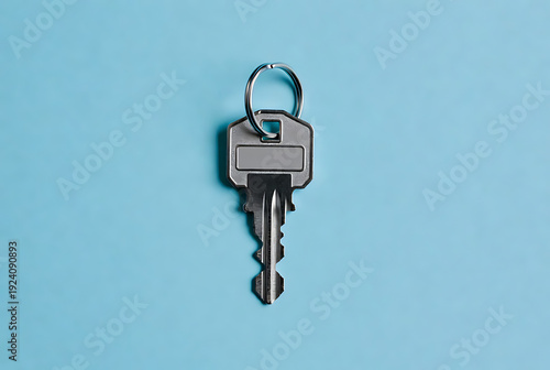 Wallpaper Mural Key silver metal with keyring attached to top on blue background, perfect for security or access concepts featuring lock, door, house with home and apartment elements for office, padlock projects, Torontodigital.ca