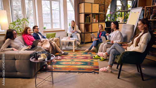 Photos Diverse team meeting in cozy loft office with laptops and coffee