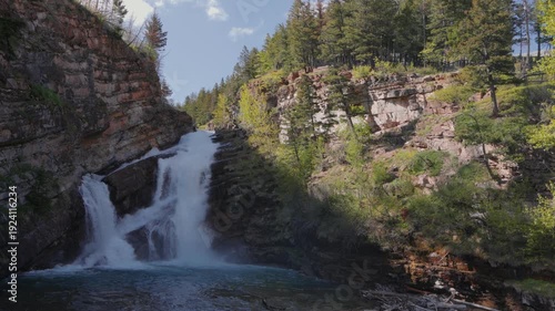 Wallpaper Mural Cameron Falls cascading into clear turquoise water surrounded by rocky cliffs and green forest in Waterton Lakes National Park Torontodigital.ca