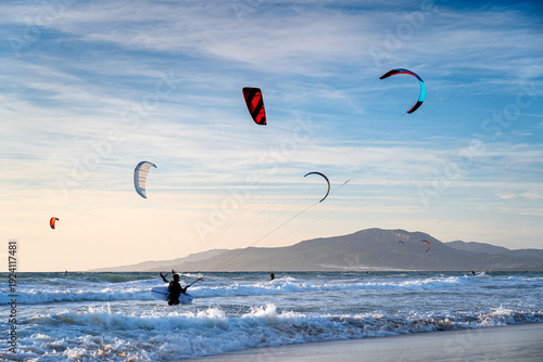 Kitesurfers at sunset in Tarifa, a surfers' paradise in Spain.