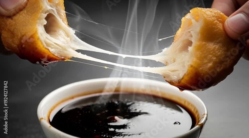 A crispy, golden-brown Pempek (fish cake) is being broken open, revealing its soft, chewy interior. It's moments away from being dipped into a dark