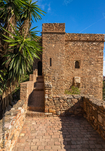 View of the historic Alcazaba fortress in Malaga. Moorish military architecture with brick walls, gardens, and arches from the Islamic period in Andalusia, Spain