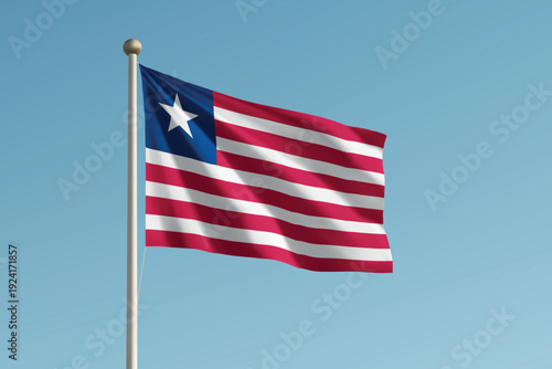 Liberia national flag waving on pole against clear blue sky background.