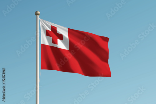 Tonga national flag waving on pole against clear blue sky background.