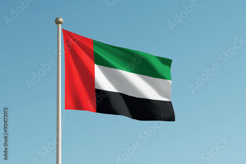 United Arab Emirates national flag waving on pole against clear blue sky background.