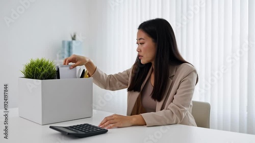 A stressed businesswoman sitting at her desk with her hand on her forehead looking frustrated