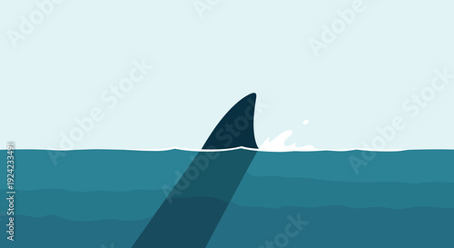 Ominous shark fin cuts through the surface of the calm blue ocean water with a subtle splash and a shadow underneath.