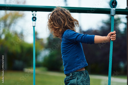 Young child on play equipment in the park