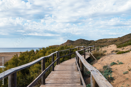Wallpaper Mural Wooden walkway leading to the beach in Menorca under a cloudy sky. Torontodigital.ca