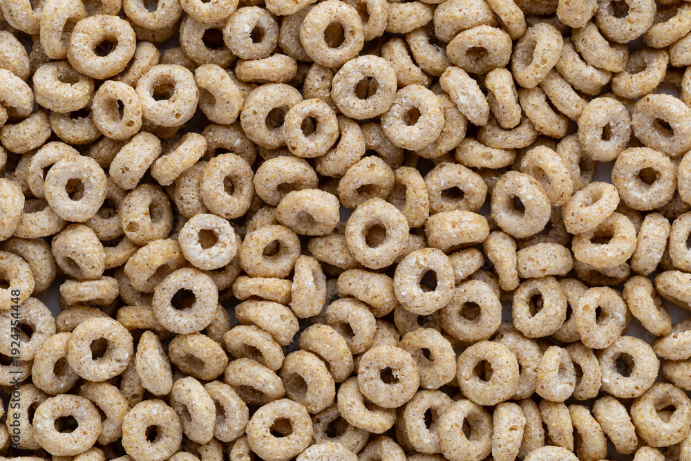 Naklejka premium Cereal rings spread across a flat surface for a simple presentation displaying texture and shape