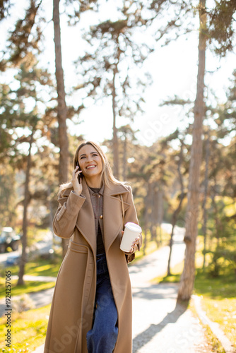Woman walks in park while t...