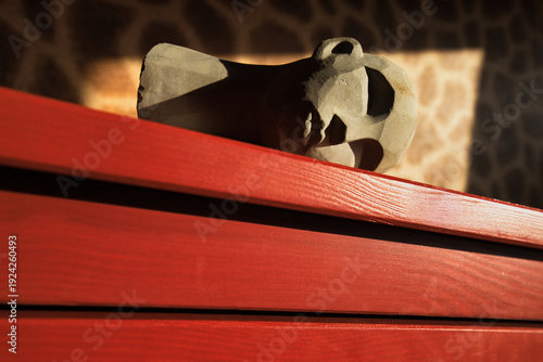 Cuadro en lienzo The Fall of Africa: Fallen stone head statue on red background, conceptual image for political instability, economic collapse, and continental crisis