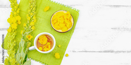 Cup of herbal tea with mullein flowers and leaves. Natural light, alternative medicine