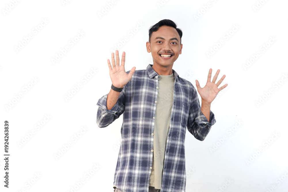 Naklejka premium Asian man wearing a plaid shirt with a friendly expression is waving hello on an isolated white background.