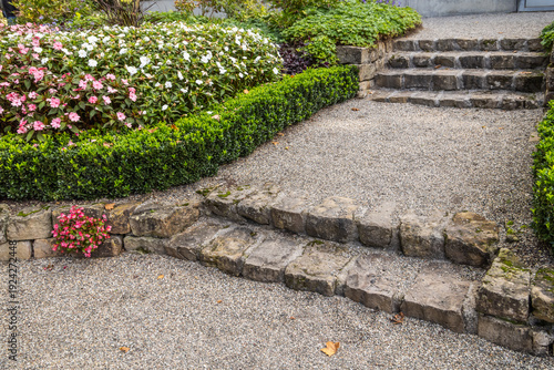 Stone garden stairs with flowerbed and hedge