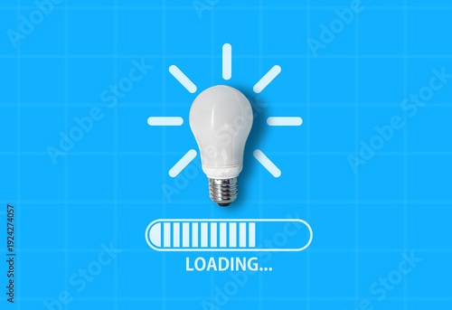 Light bulb on blue background with computer loading bar below and text ‘Loading…’ – symbolizing ideas in progress, creativity under development, and innovation about to launch