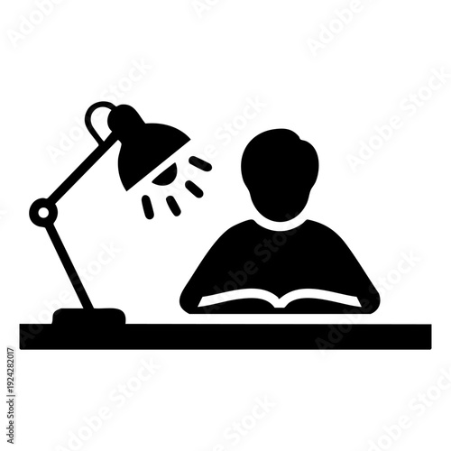 student studying at a desk lamp