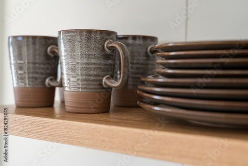 Kitchen open shelf with ceramic plates, mugs and bowls