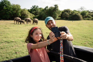 Family selfie with elephants in safari. Travel Sri Lanka 