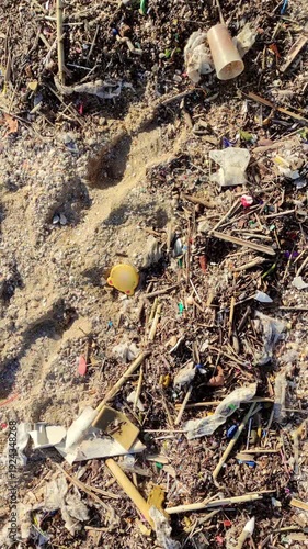 Beach with debris after the storm.
Close-up of the beach sand with waste material thrown by the sea onto the shore. Vertical format