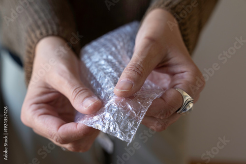 Hands of an unrecognizable person popping bubbles on a piece of bubble wrap.
Conceptual image of anxiety, Obsessive-Compulsive Disorder