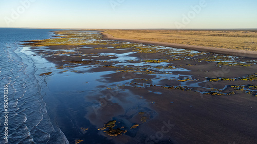 Wide aerial view of the rugged Atlantic coastline near San Antonio Este at low tide.