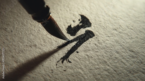 Close-up of brush painting black ink on textured paper