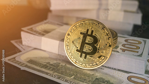 Gold bitcoin coin standing on stacks of US dollar bills, close-up finance concept with warm sunlight, cryptocurrency investment and digital money theme. Bitcoin coin on USdollar bills stacks.