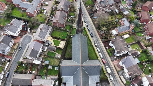 Aerial shot of Christ Church Birkenhead with its tall spire under soft daylight.