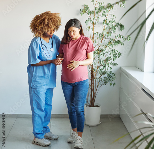Wallpaper Mural Portrait of a young happy pregnant woman exercising with doctor or nurse during a visit at home or in a clinic, consultation appointment and  giving support and helping walk Torontodigital.ca