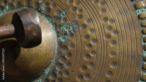 Close up of antique weathered bronze cymbal with hammered texture and patina detail