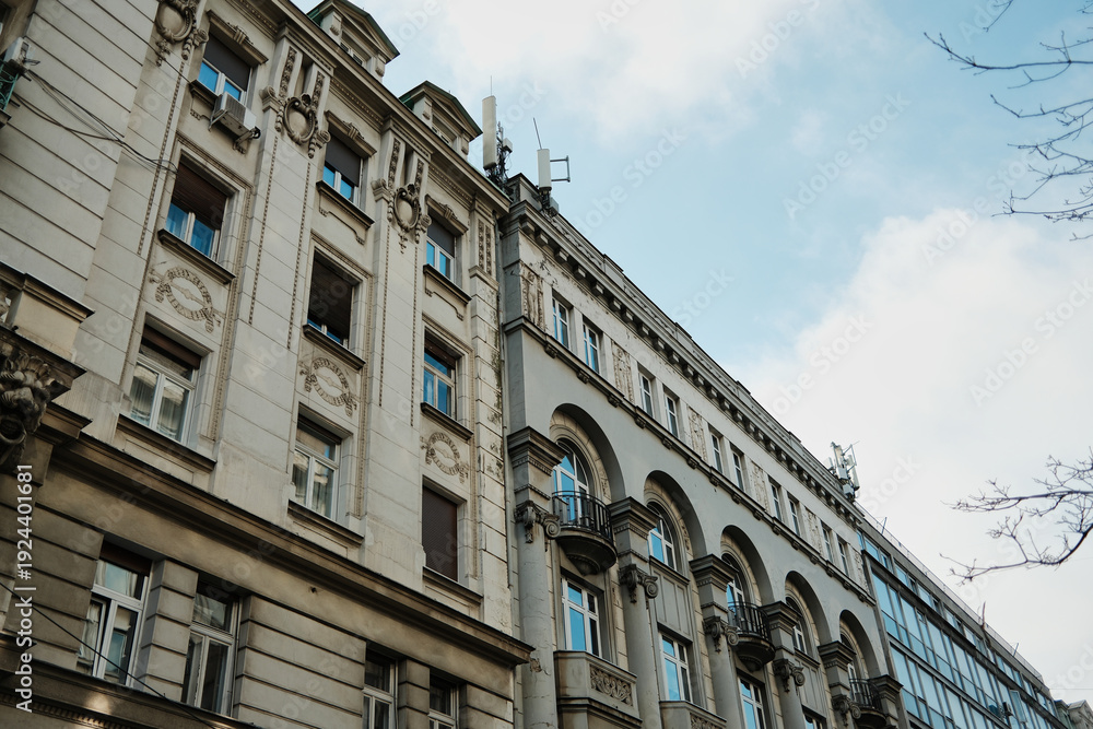 Fototapeta premium Historic urban facade with decorative elements and balconies creating architectural perspective in Belgrade.