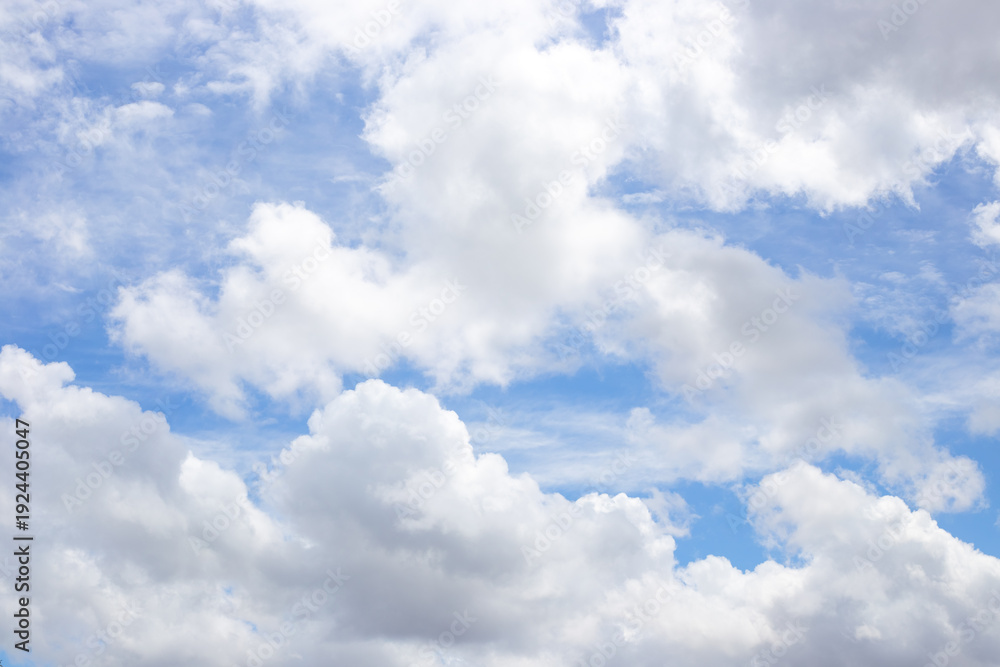 Obraz premium White cumulus clouds drift across a blue sky on a sunny afternoon. weather forecast, summer atmosphere, nature background.