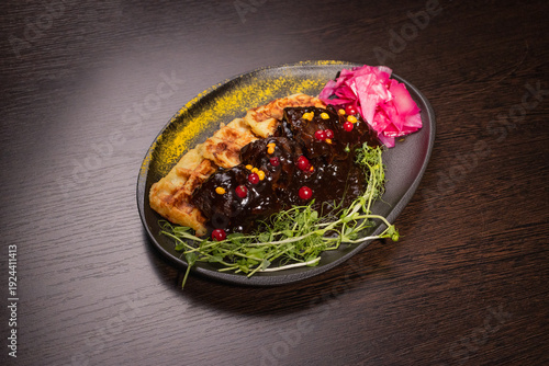 Fried meat with potato waffles and herbs on a plate