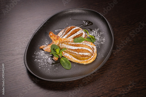 Dessert of fried pear sprinkled with powdered sugar