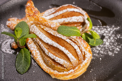 Dessert of fried pear sprinkled with powdered sugar