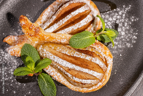 Dessert of fried pear sprinkled with powdered sugar