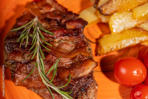 Steak with fried potatoes and tomatoes on a plate
