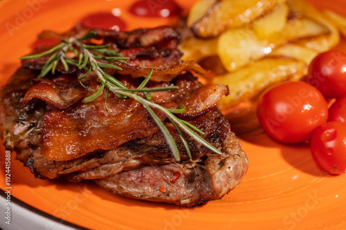 Steak with fried potatoes and tomatoes on a plate