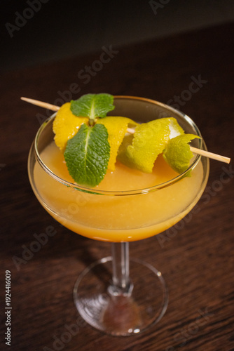 A alcoholic cocktail with orange juice is beautifully decorated by the bartender