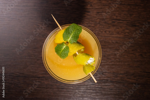 A alcoholic cocktail with orange juice is beautifully decorated by the bartender