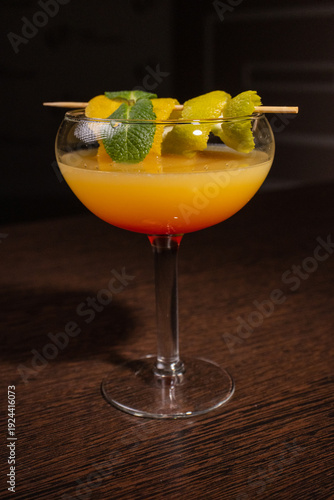 A alcoholic cocktail with orange juice is beautifully decorated by the bartender