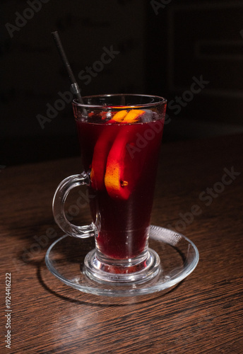 Mulled wine in a glass on a wooden table