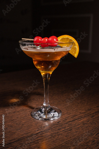 A champagne cocktail in a beautiful glass with pickled berries on a skewer