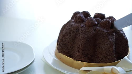 A woman cutting Profiteroles cake  with a knife on white background