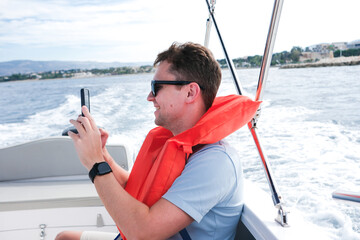 Man Enjoying a Boat Ride While Taking Photos on a Sunny Day