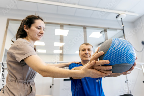Foto Physiotherapist assisting male patient with rehabilitation exercises using a wei
