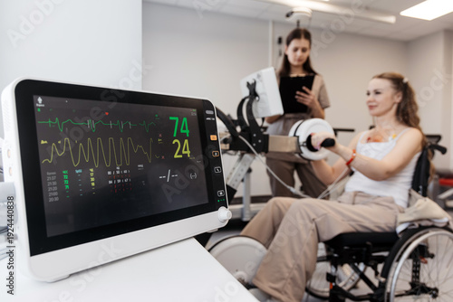 Fotografija Woman training on rehabilitation bike during medical evaluation under therapist supervision
